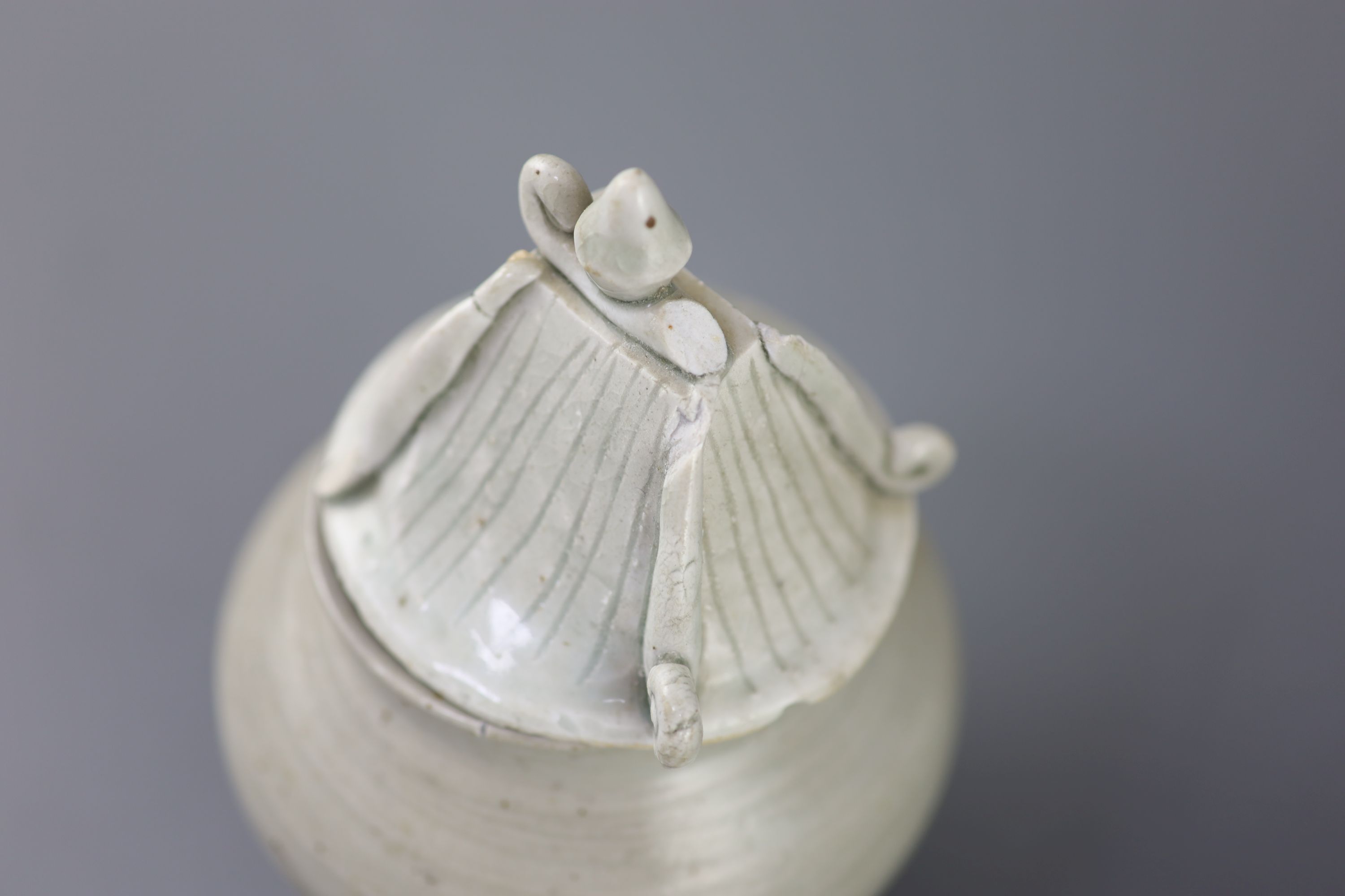 A Chinese cream glazed ovoid jar, Tang dynasty and a Ding type jar and cover, Yuan dynasty,